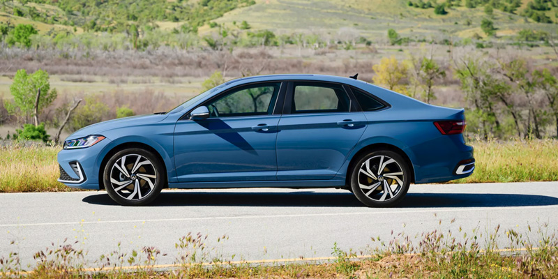 2025 Volkswagen Jetta parked on road with grassy landscape, side view
